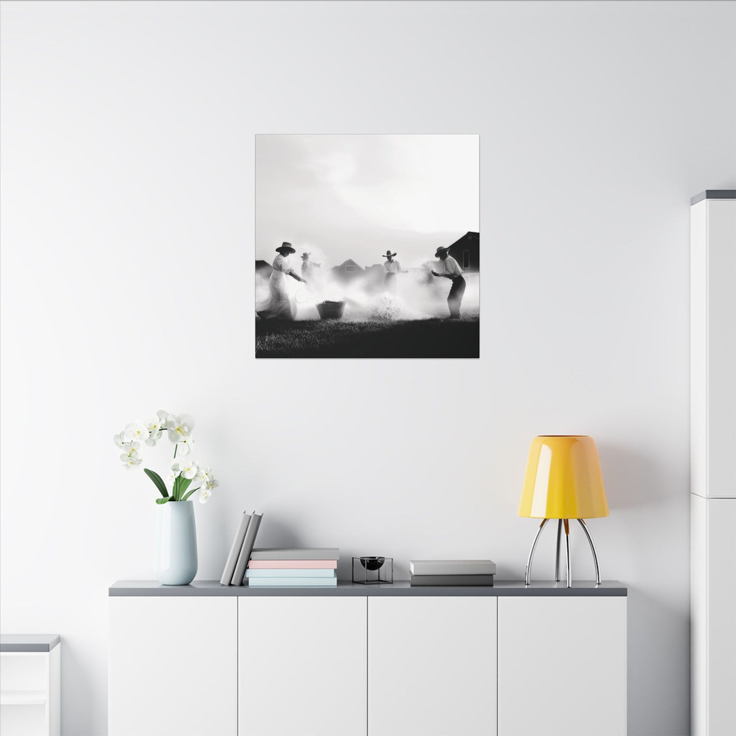 Shown in light colored room. Canvas print of a Western family joyfully splashing water in a sunlit yard, dressed in prairie-style clothing, captured in black and white.