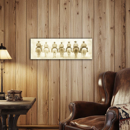 Room view. Sepia-toned art print featuring seven cowboys on horseback riding away in unison through a dusty Western town.