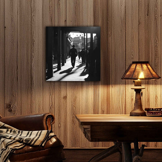 In room. Canvas print of a silhouetted cowboy walking down a wooden sidewalk in a Western town, with long shadows and dramatic black-and-white lighting.