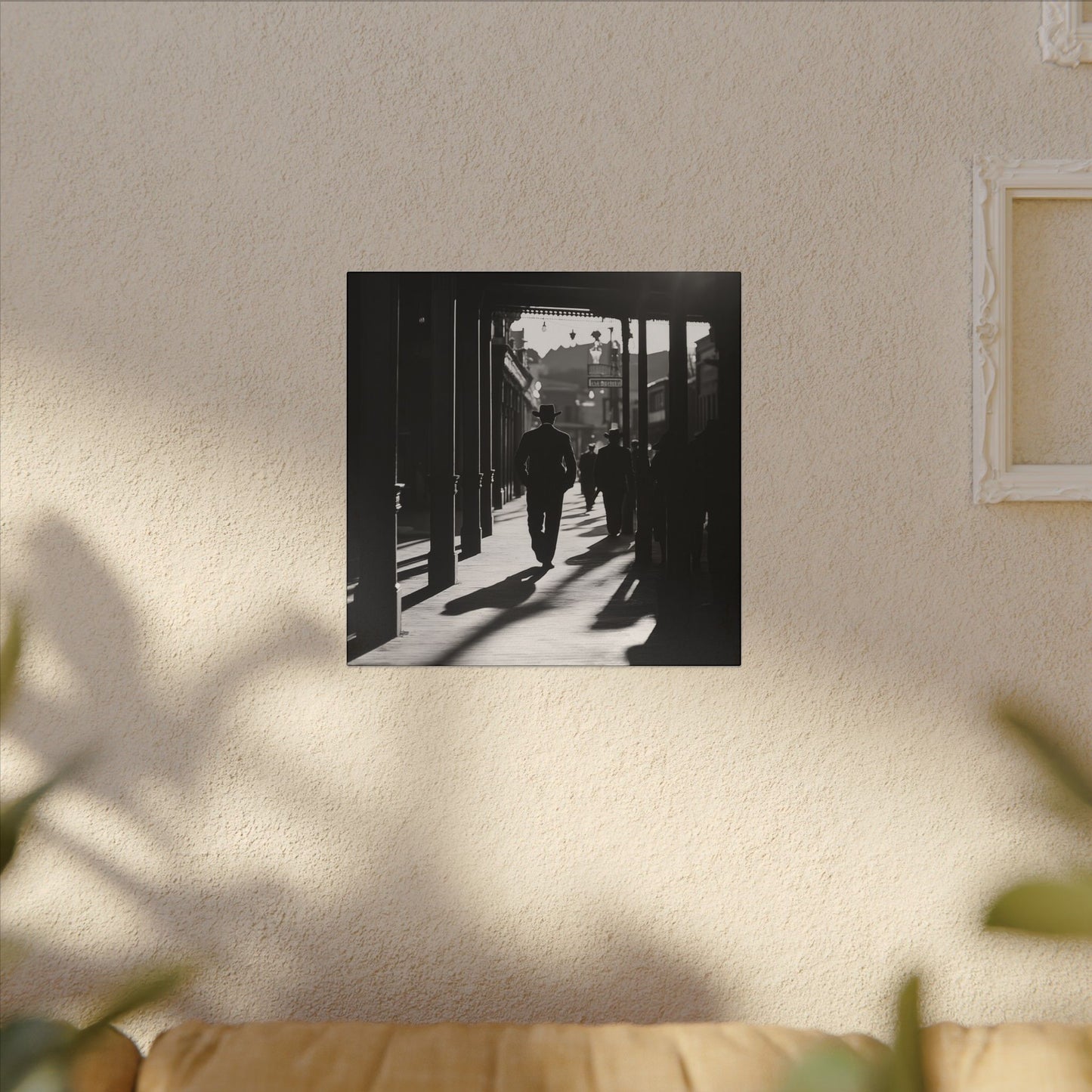 Alternate view in room. Canvas print of a silhouetted cowboy walking down a wooden sidewalk in a Western town, with long shadows and dramatic black-and-white lighting.